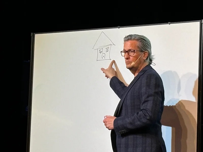 Johan Appel visar det ritade huset på en whiteboard under en föreläsning