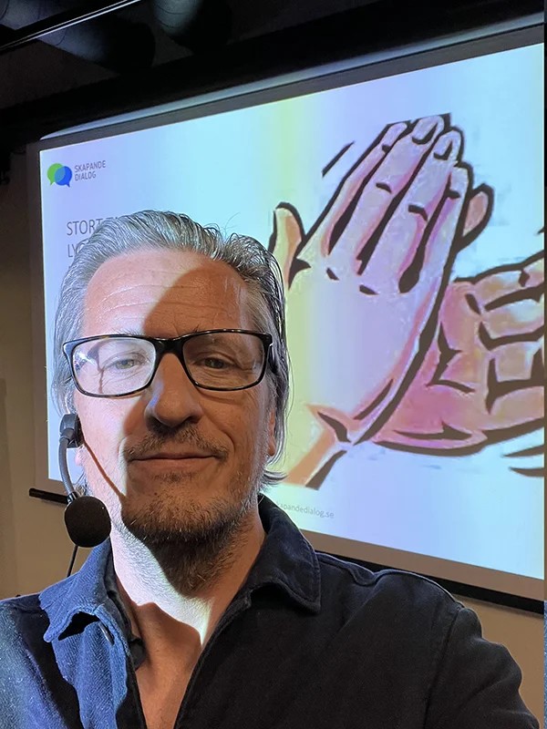 Johan Appel framför en projicerad bild med texten Skapande dialog